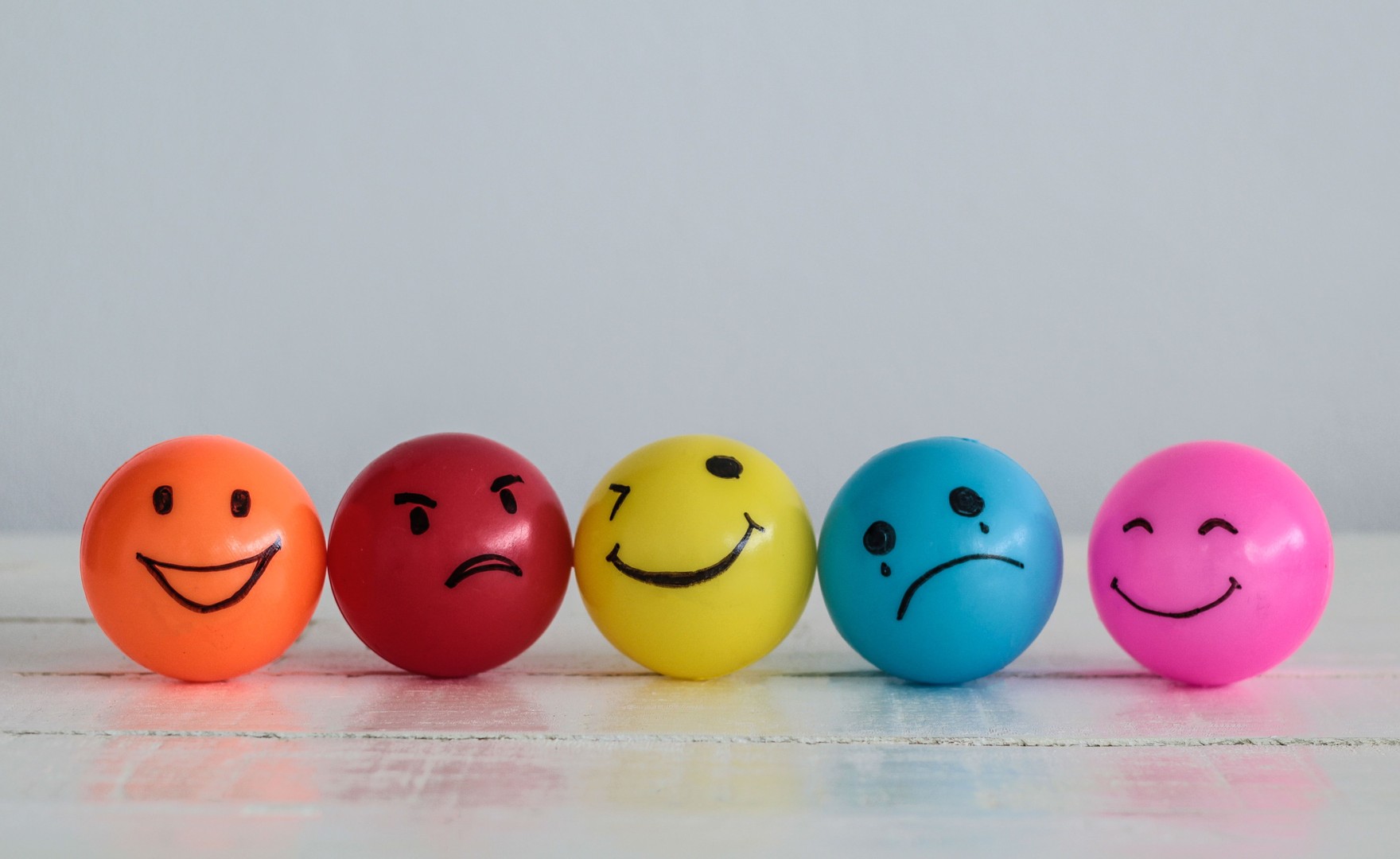 Row of bouncy balls with alternating smiling and sad faces