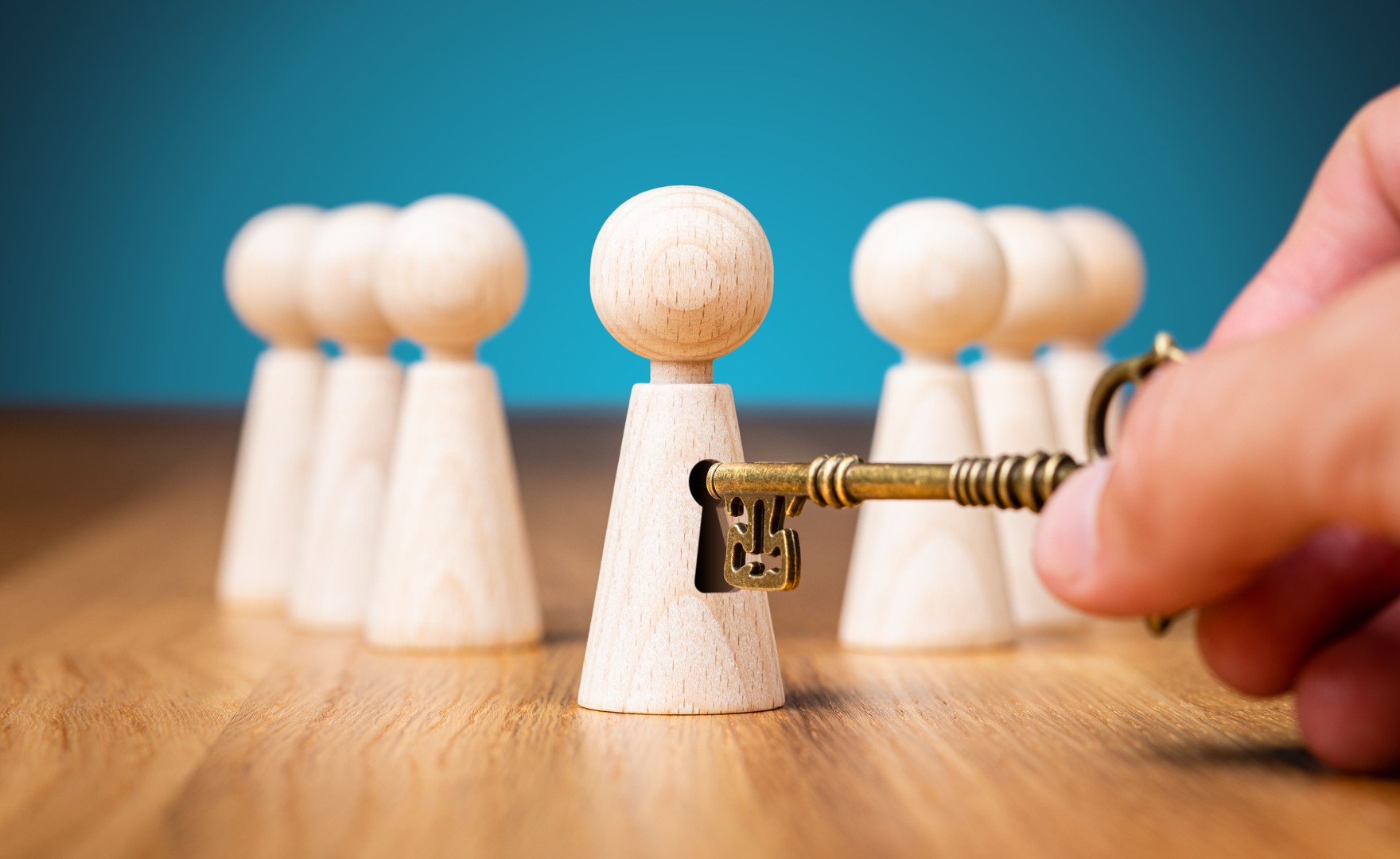Conceptual image of golden key unlocking a small wooden figure