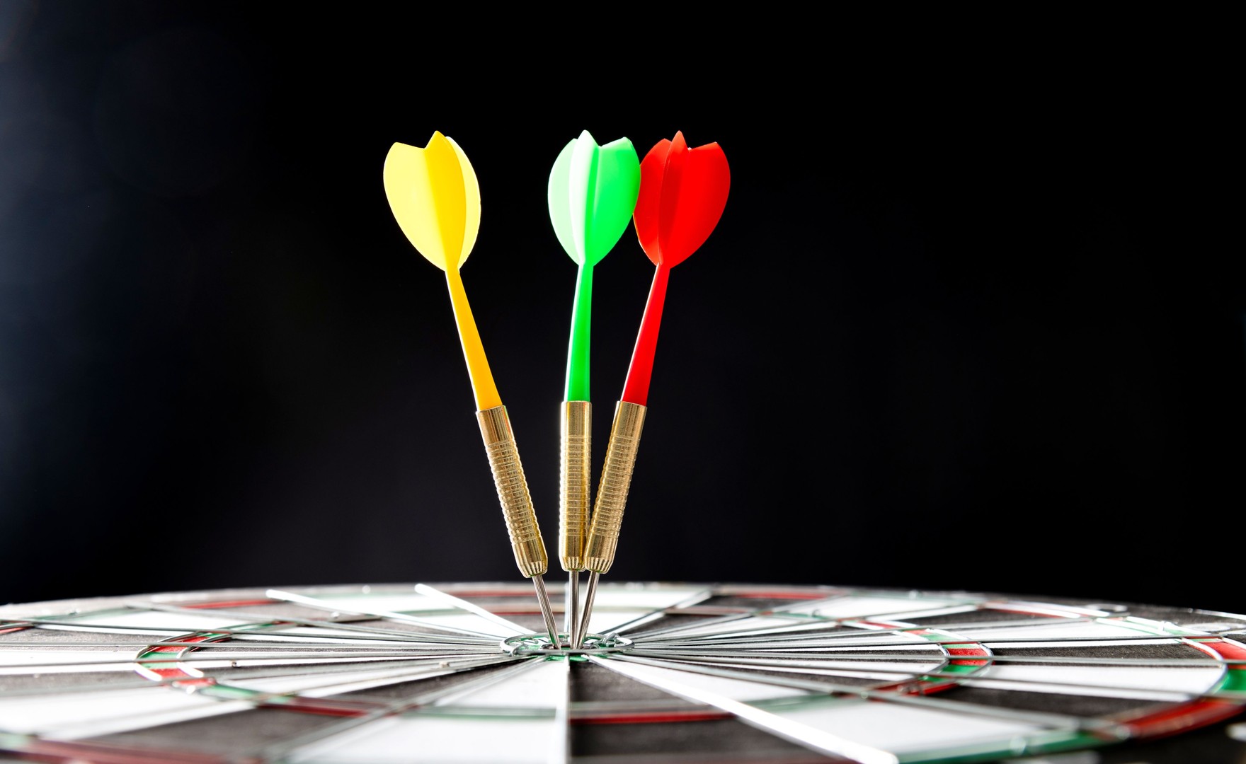 Image of three darts hitting on centre target.