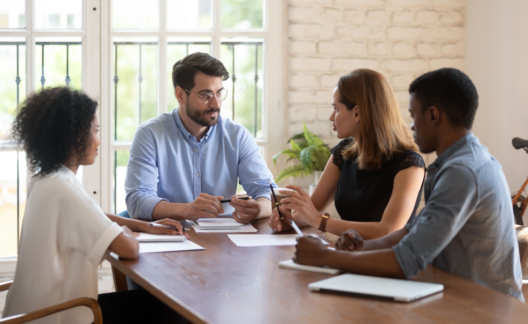 2 men and 2 women sat around a table discussing work