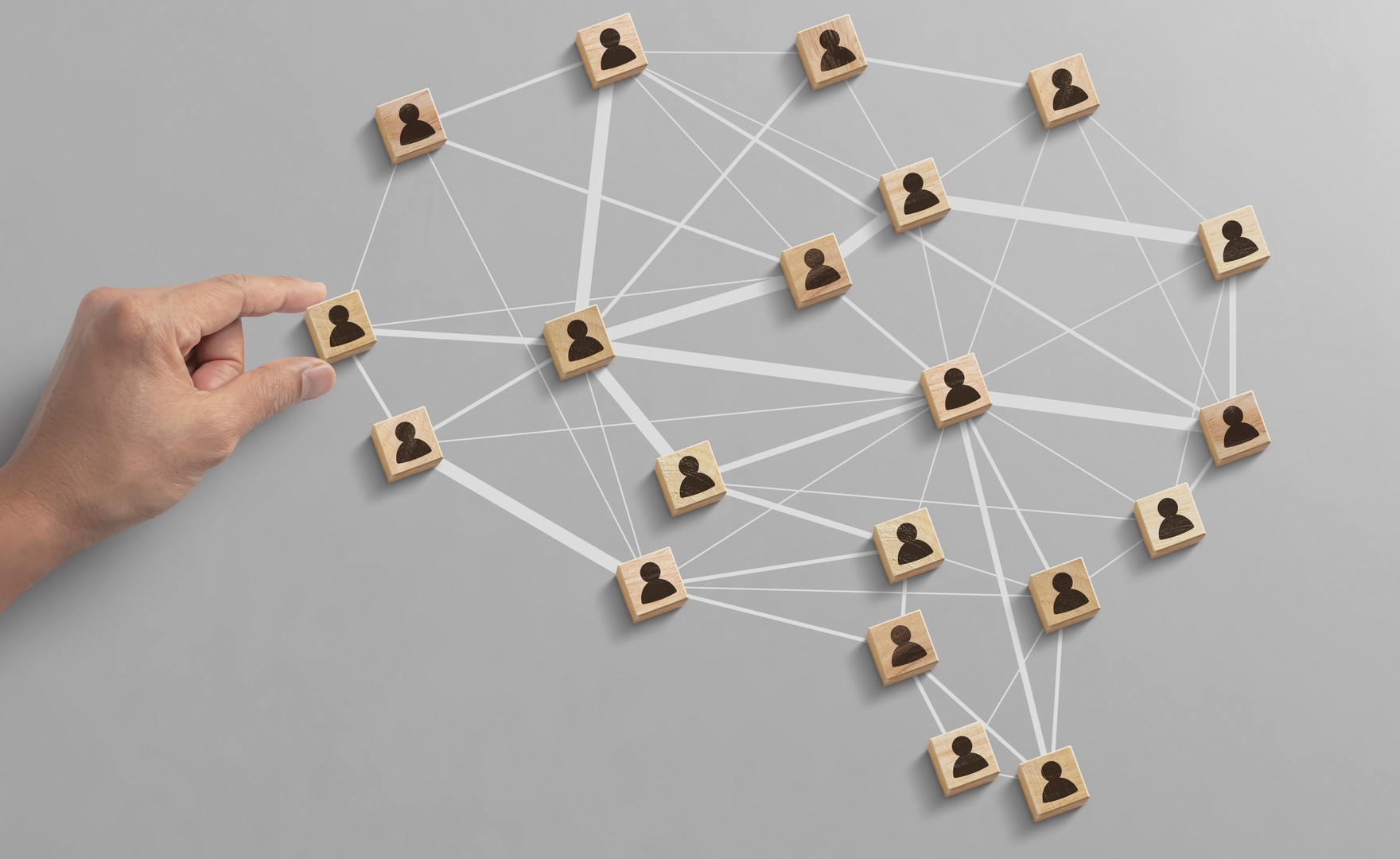 several figures painted on wooden blocks interlinked by a web