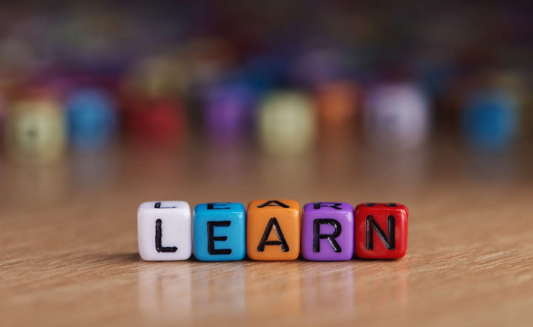Colourful blocks spelling out the word 'learn' on a wooden table