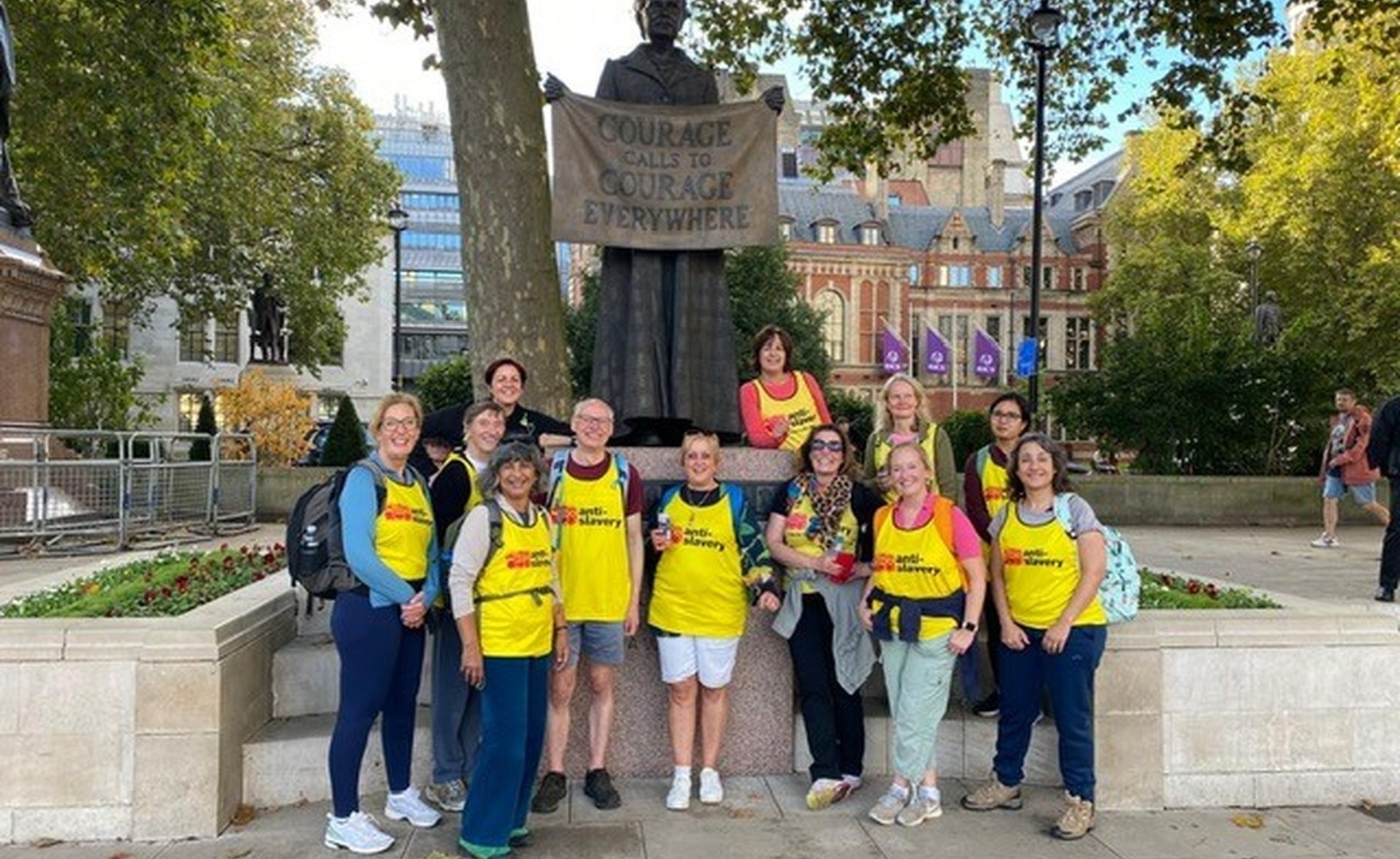 AoEC staff team standing by a statue of Millicent Fawcett